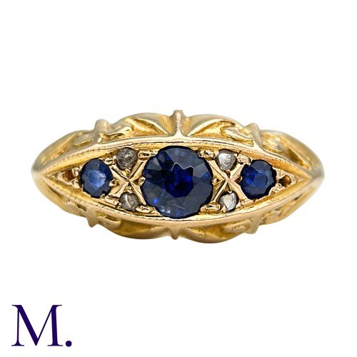 14 - A Sapphire And Diamond Ring in 18k yellow gold, Seth with three round cut blue sapphire punctuated b... 