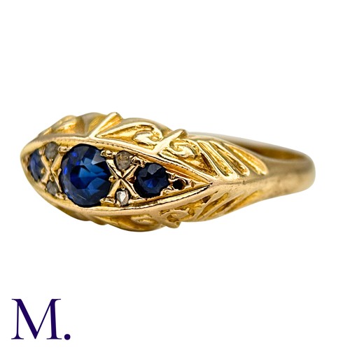 14 - A Sapphire And Diamond Ring in 18k yellow gold, Seth with three round cut blue sapphire punctuated b... 