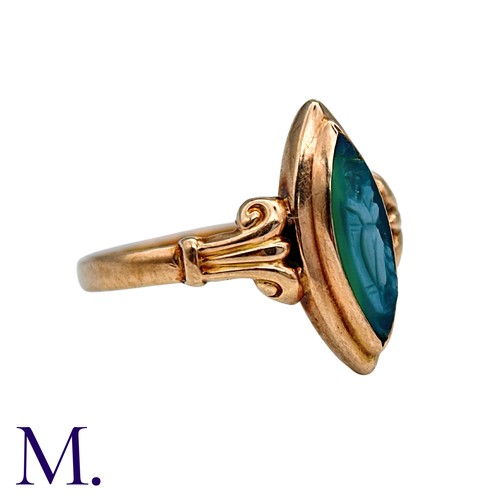 210 - A Cameo Ring in 9k yellow gold, the navette shaped face set with a carved green cameo, to scrolling ... 