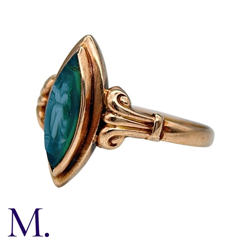 210 - A Cameo Ring in 9k yellow gold, the navette shaped face set with a carved green cameo, to scrolling ... 