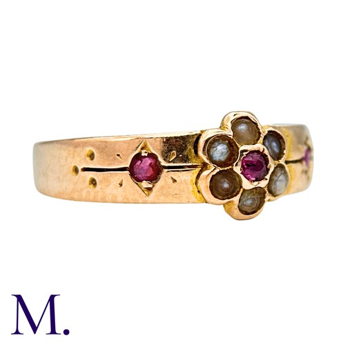 25 - A Ruby And Pearl Gypsy Ring in 15k yellow gold, set with a round cut ruby within a pearl border, fla... 