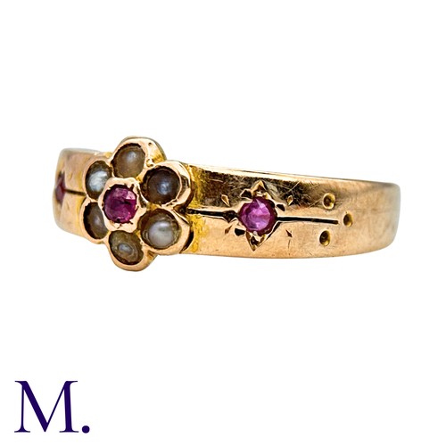 25 - A Ruby And Pearl Gypsy Ring in 15k yellow gold, set with a round cut ruby within a pearl border, fla... 