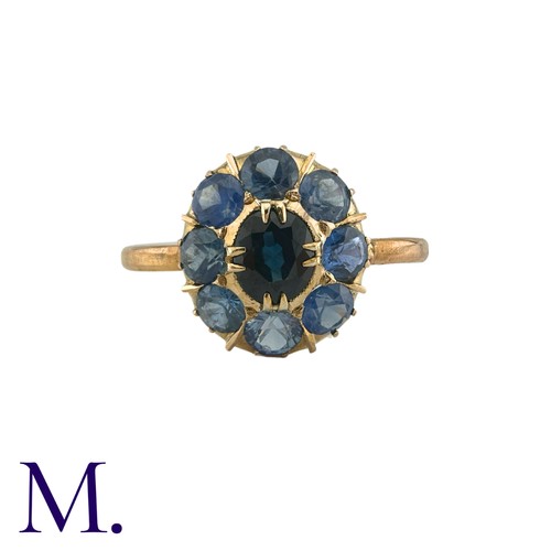 182 - A Sapphire Cluster Ring in yellow gold, comprising a cluster of round cut sapphires surrounding a pr... 