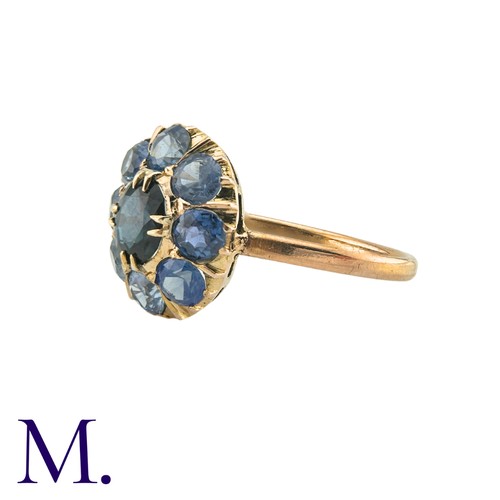 182 - A Sapphire Cluster Ring in yellow gold, comprising a cluster of round cut sapphires surrounding a pr... 