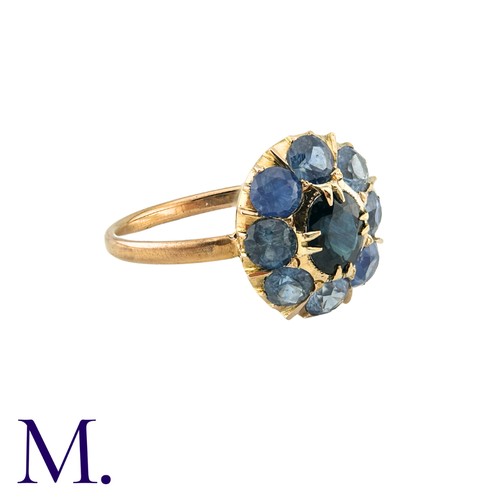 182 - A Sapphire Cluster Ring in yellow gold, comprising a cluster of round cut sapphires surrounding a pr... 