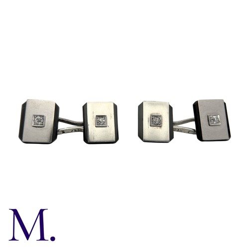 228 - A Pair of Onyx And Diamond Cufflinks in platinum, each set with a diamond weighing approximately 0.1... 