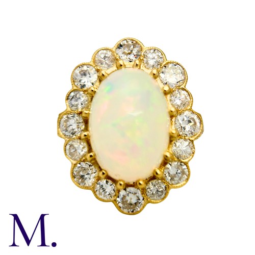 230 - An Opal And Diamond Cluster Ring in 18k yellow gold, set with a principal cabochon opal of approxima... 