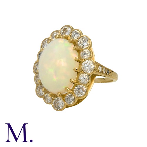 230 - An Opal And Diamond Cluster Ring in 18k yellow gold, set with a principal cabochon opal of approxima... 