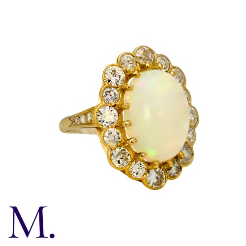 230 - An Opal And Diamond Cluster Ring in 18k yellow gold, set with a principal cabochon opal of approxima... 