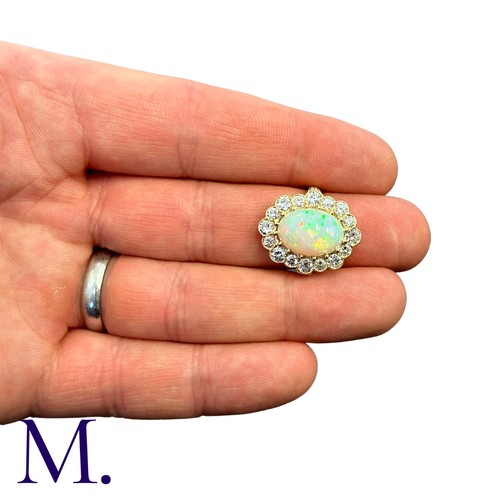 230 - An Opal And Diamond Cluster Ring in 18k yellow gold, set with a principal cabochon opal of approxima... 