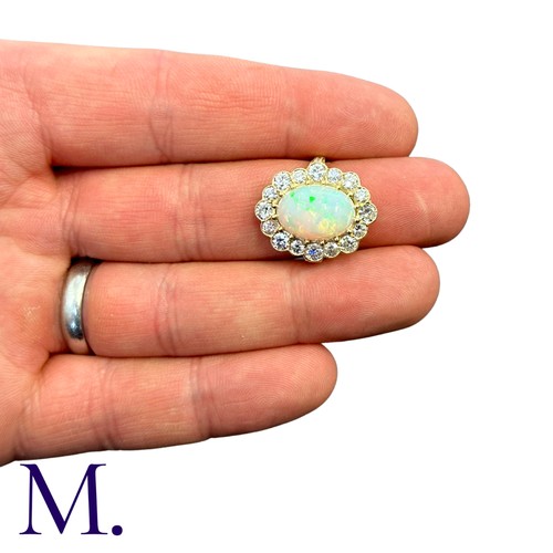 230 - An Opal And Diamond Cluster Ring in 18k yellow gold, set with a principal cabochon opal of approxima... 