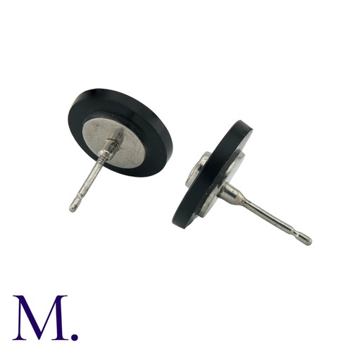 216 - A Pair Of Onyx And Diamond Stud Earrings in platinum, the concaved onyx discs each set centrally wit... 