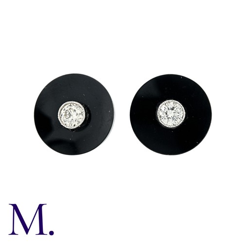 216 - A Pair Of Onyx And Diamond Stud Earrings in platinum, the concaved onyx discs each set centrally wit... 