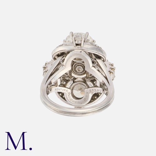 51 - BOUCHERON. A Pearl and Diamond Ring with box.  Set with two round transitional cut diamonds above ei... 