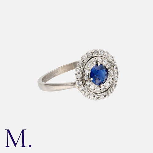 13 - An Art Deco Sapphire And Diamond Cluster Ring in platinum, set with a principal round cut sapphire o... 