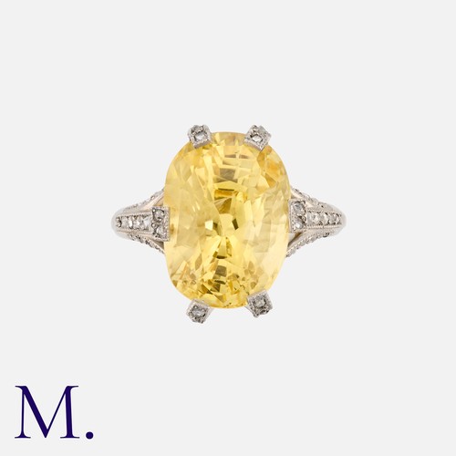 22 - A Yellow Sapphire And Diamond Ring in platinum, set with a principal yellow sapphire of approximatel... 