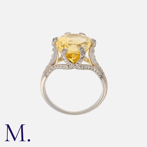 22 - A Yellow Sapphire And Diamond Ring in platinum, set with a principal yellow sapphire of approximatel... 