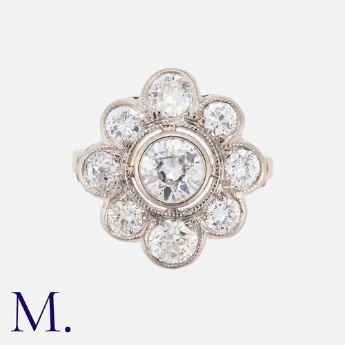 61 - A Diamond Cluster Ring in white gold, set with a principal transitional cut diamond of approximately... 
