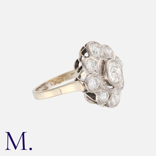 61 - A Diamond Cluster Ring in white gold, set with a principal transitional cut diamond of approximately... 