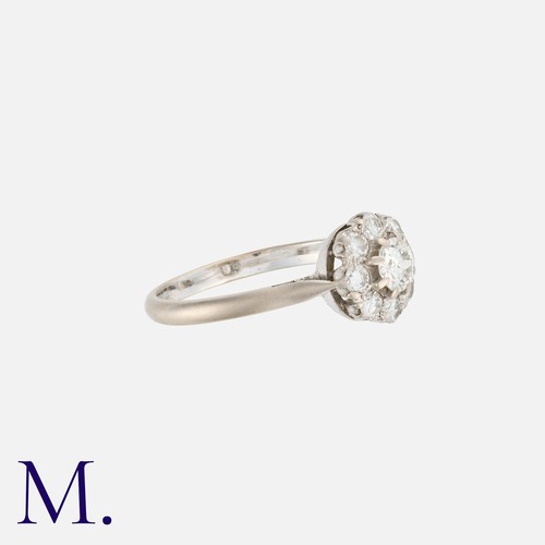 6 - A Diamond Cluster Ring in 18k white gold, comprising a central round cut diamond within a border of ... 