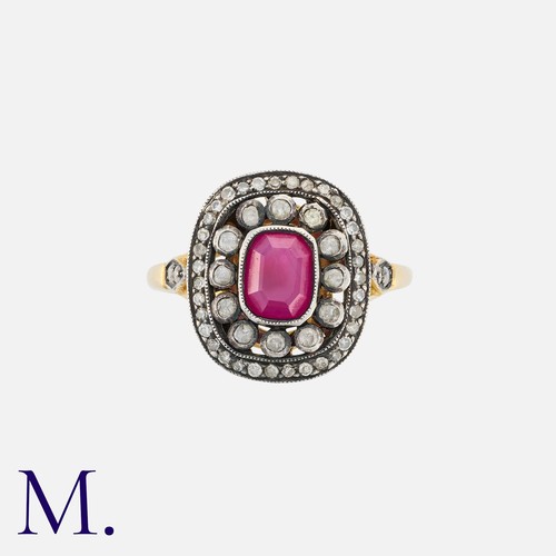 39 - A Ruby and Diamond Cluster Ring in 18k yellow gold and silver, comprising a stepped cut ruby within ... 