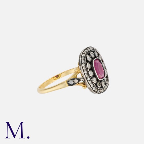 39 - A Ruby and Diamond Cluster Ring in 18k yellow gold and silver, comprising a stepped cut ruby within ... 