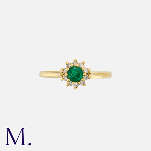 37 - An Emerald and Diamond Ring in 18ct yellow gold, set with a round cut emerald to the centre with ten... 