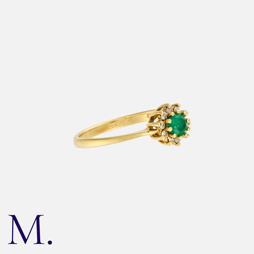 37 - An Emerald and Diamond Ring in 18ct yellow gold, set with a round cut emerald to the centre with ten... 