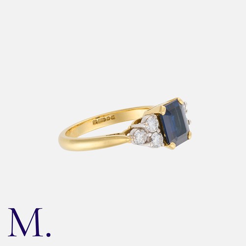19 - A Sapphire And Diamond Ring in 18k yellow gold, the central step cut sapphire of approximately 1.50c... 