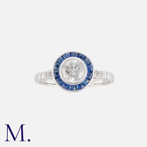51 - A Sapphire And Diamond Target Ring in 18k white gold set with a central round cut diamond of approxi... 