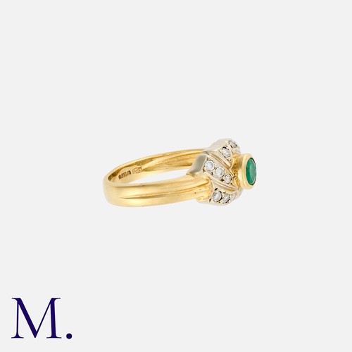 196 - An Emerald and Diamond Ring in 18K yellow gold, set with a round cut emerald to the centre of of whi... 