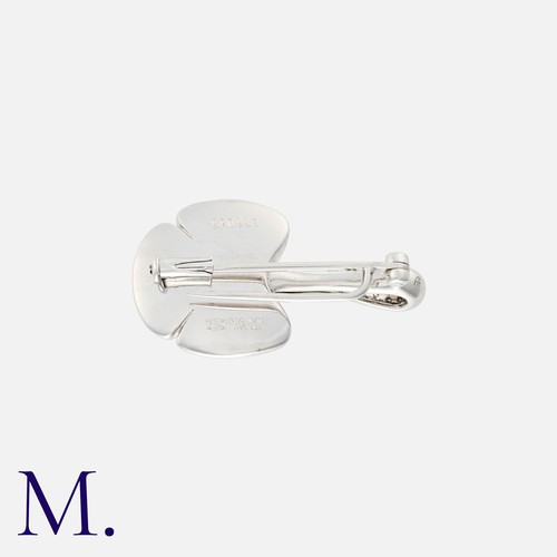 85 - CHAUMET, A Diamond Flower Brooch in 18k white gold, designed as an abstract flower, set with round c... 