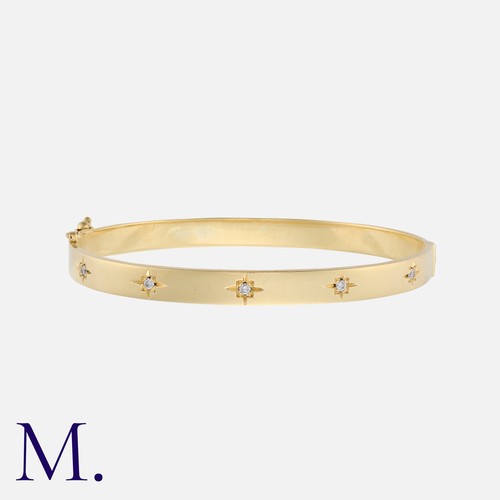 172 - A Diamond Bangle in 14k yellow gold, the hinged bangle set to the front with five round cut diamonds... 