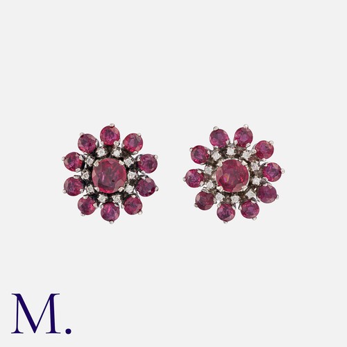 230 - A Pair Of Ruby And Diamond Cluster Stud Earrings in 18k white gold, set centrally with a round cut r... 