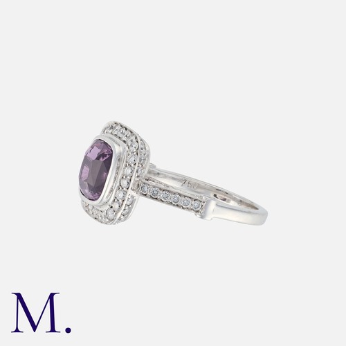 132 - A Pink Sapphire And Diamond Dress Ring in 18k white gold, set principally with a cushion cut pink sa... 