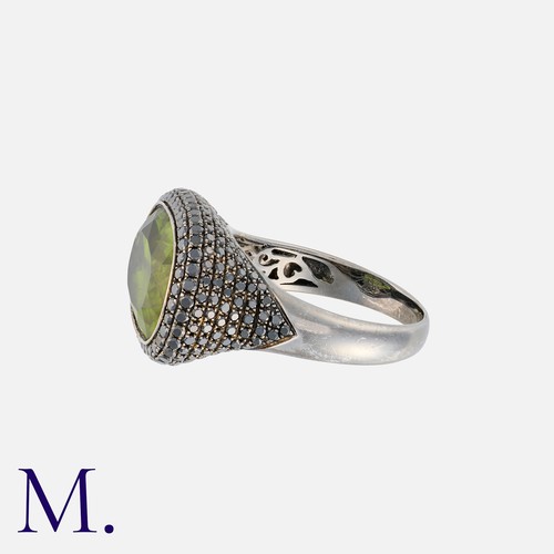 237 - A Peridot And Black Diamond Ring in 18k blackened gold. Set with a principal elongated cushion cut p... 