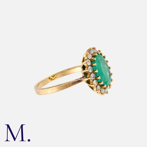 65 - An Emerald & Diamond Cluster Ring in 18K yellow gold, with an oval-cut emerald to the centre with 16... 