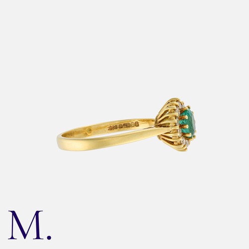 202 - An Emerald and Diamond Ring in 18K yellow gold, set with an oval cut emerald to the centre with ten ... 