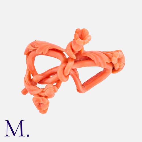 185 - A Coral Brooch with yellow gold pin.  The coral, carved into a bow pattern with floral accents.  The... 