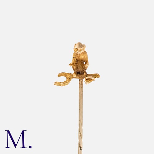 214 - A Novelty Stick Pin in yellow gold and yellow metal, the terminal designed as a monkey sat on a bran... 