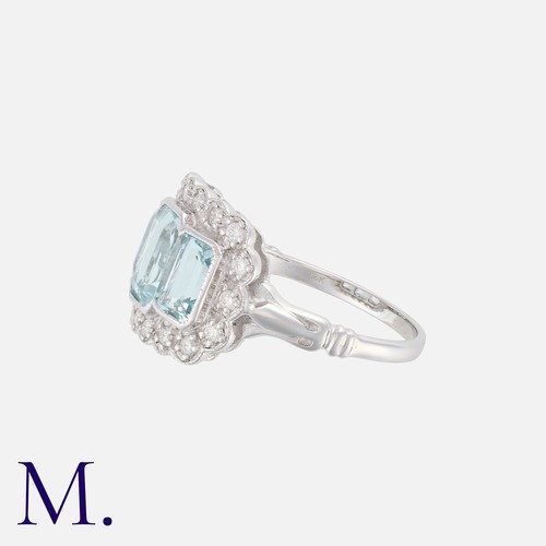 129 - An Aquamarine & Diamond Three Stone Ring in 18k white gold, set with three step cut aquamarines, acc... 