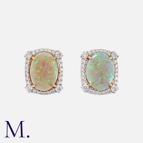 167 - A Pair Of Opal And Diamond Earclips in 28k white gold, each comprising an oval shaped cabochon opal ... 