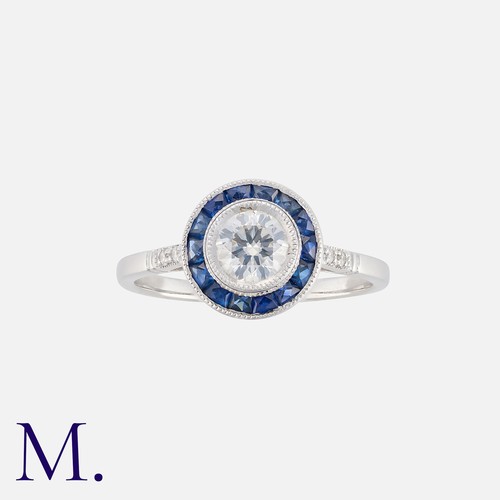 147 - A Sapphire And Diamond Target Ring in 18k white gold, set with a central round cut diamond of approx... 