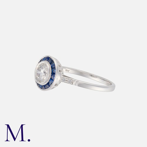 147 - A Sapphire And Diamond Target Ring in 18k white gold, set with a central round cut diamond of approx... 