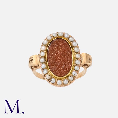 208 - A Goldstone and Pearl Ring in yellow gold, set with an oval plaque of goldstone with pearls in surro... 