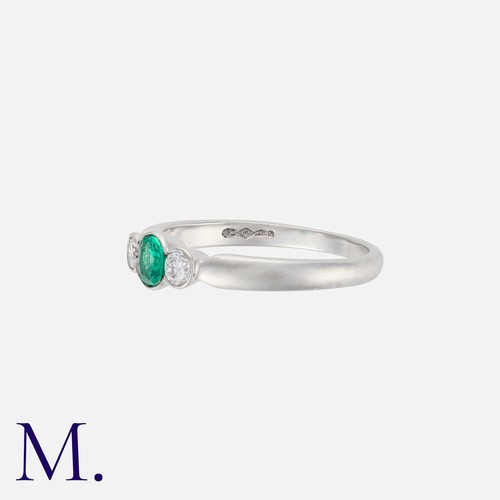 94 - An Emerald and Diamond Ring in 18K yellow gold, set with a round cut emerald to the centre with bril... 