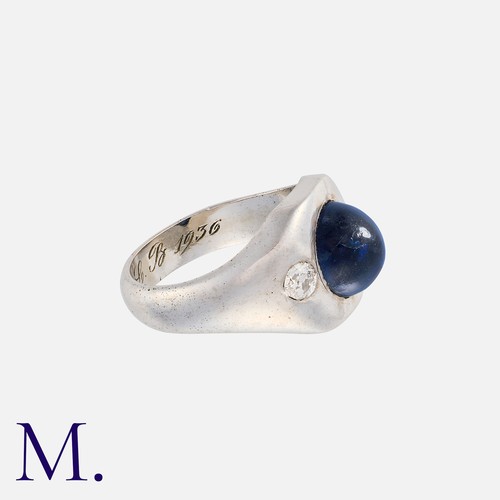 141 - A Sapphire And Diamond Gypsy Ring in 18k white gold, set with a central cabochon sapphire, flanked e... 