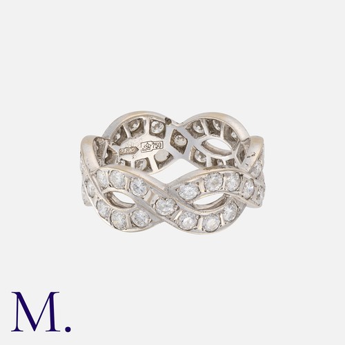 166 - A Diamond Eternity Ring in 18k white gold, designed as two woven undulating bands set with round cut... 