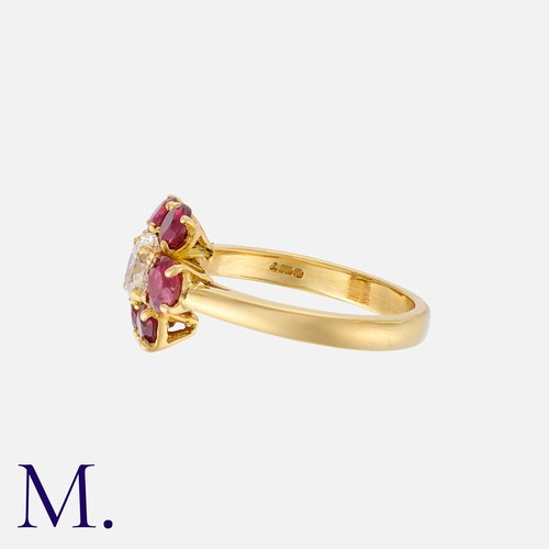 223 - A Ruby And Diamond Cluster Ring in 18k yellow gold, set with a principal oval cut diamond within a b... 