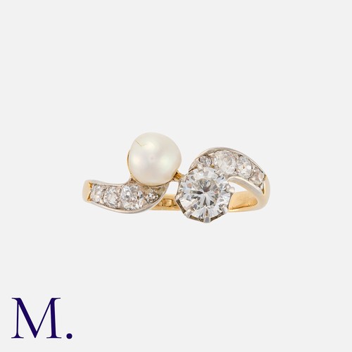 153 - A Pearl And Diamond Toi Et Moi Ring in yellow gold, in crossover design, set with a round cut diamon... 